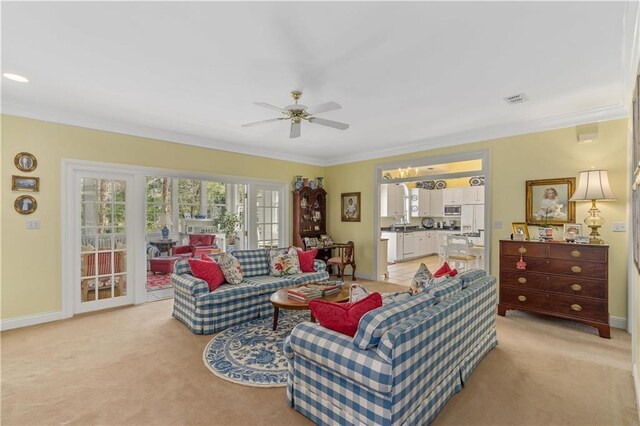 living room with ornamental molding, ceiling fan, light colored carpet, and baseboards