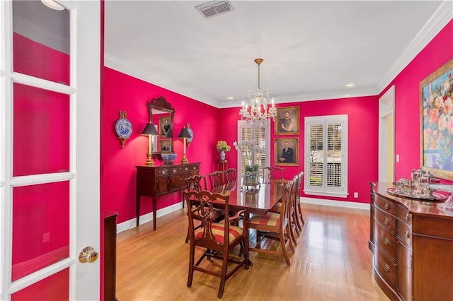 dining area featuring a chandelier, wood finished floors, ornamental molding, and baseboards