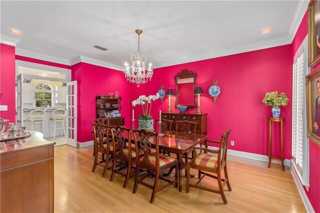 dining space featuring wood finished floors, a chandelier, crown molding, recessed lighting, and baseboards