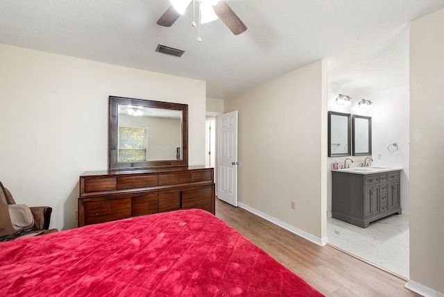 2808 Westmoor Ct, Mobile, AL 36695 - bedroom featuring baseboards, light wood-style flooring, ensuite bathroom, a sink, and a ceiling fan