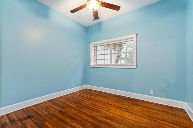 empty room featuring baseboards, dark wood-style flooring, and ceiling fan