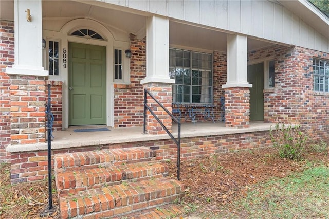 property entrance featuring brick siding and a porch