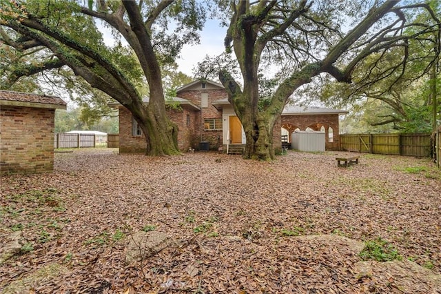 exterior space featuring fence and brick siding