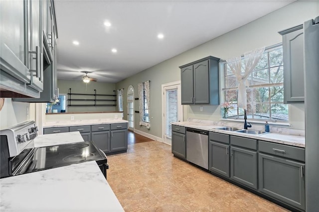 kitchen with a ceiling fan, recessed lighting, gray cabinets, a sink, and stainless steel appliances