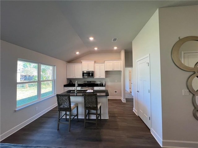 9198 Ofallon Dr N, Mobile, AL 36695 - kitchen featuring stainless steel appliances, dark countertops, white cabinetry, vaulted ceiling, and baseboards