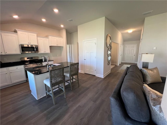 9198 Ofallon Dr N, Mobile, AL 36695 - kitchen with stainless steel appliances, open floor plan, dark countertops, a sink, and white cabinets