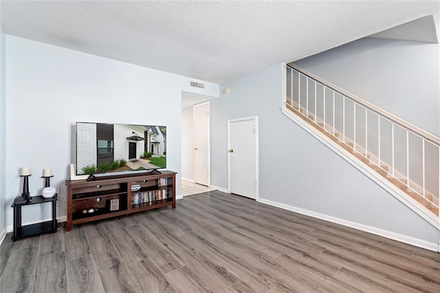 living room featuring a textured ceiling and dark wood-type flooring