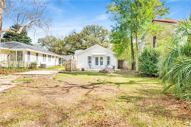 view of yard featuring central AC unit and french doors