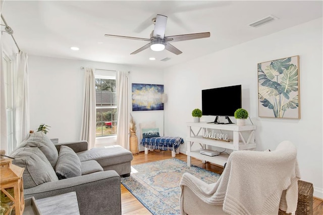 living room featuring hardwood / wood-style floors and ceiling fan