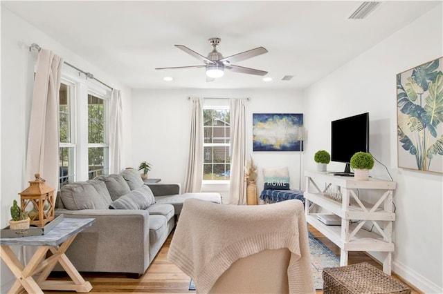 living room with ceiling fan and light hardwood / wood-style flooring