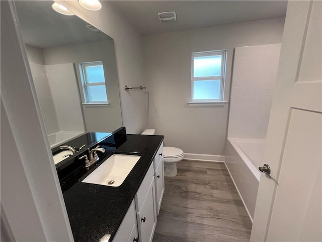 full bath featuring visible vents, toilet, wood finished floors, baseboards, and vanity