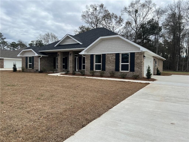 view of front facade featuring brick siding, concrete driveway, a front lawn, and a shingled roof