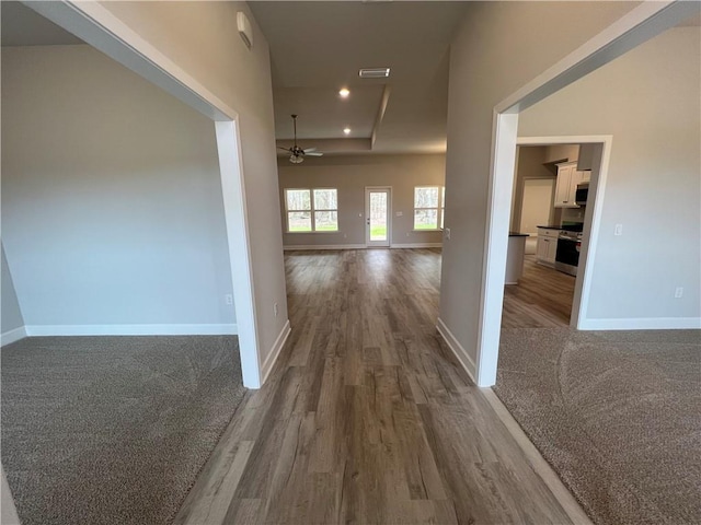 hall featuring dark wood finished floors, recessed lighting, visible vents, and baseboards