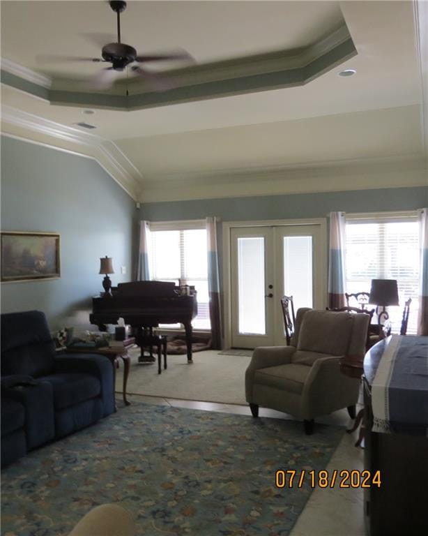 living room featuring a healthy amount of sunlight, crown molding, and a tray ceiling