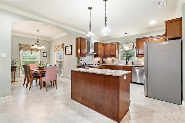 kitchen with visible vents, an inviting chandelier, arched walkways, appliances with stainless steel finishes, and wall chimney exhaust hood