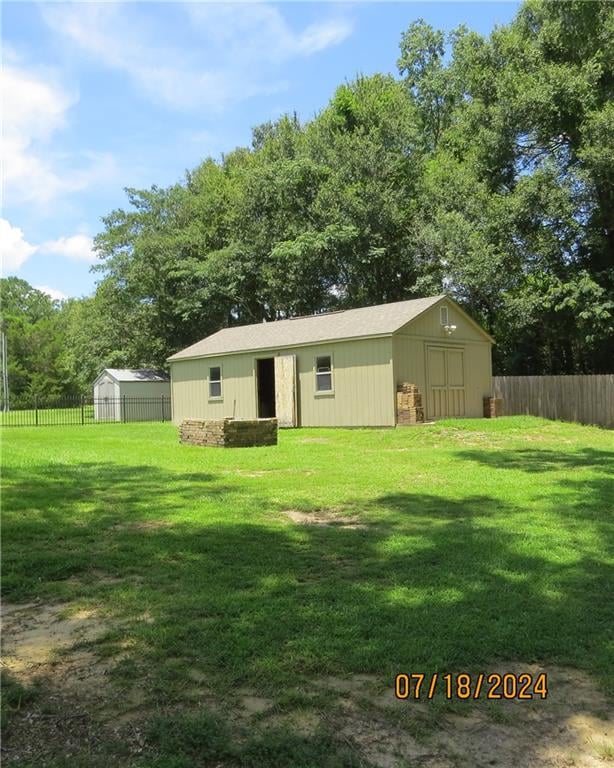 view of front of property featuring a storage unit and a front lawn