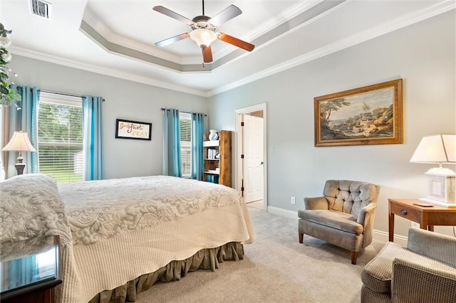 carpeted bedroom with a raised ceiling, crown molding, and ceiling fan