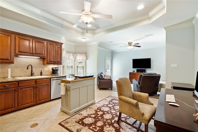 kitchen featuring backsplash, dishwasher, a tray ceiling, a ceiling fan, and a sink