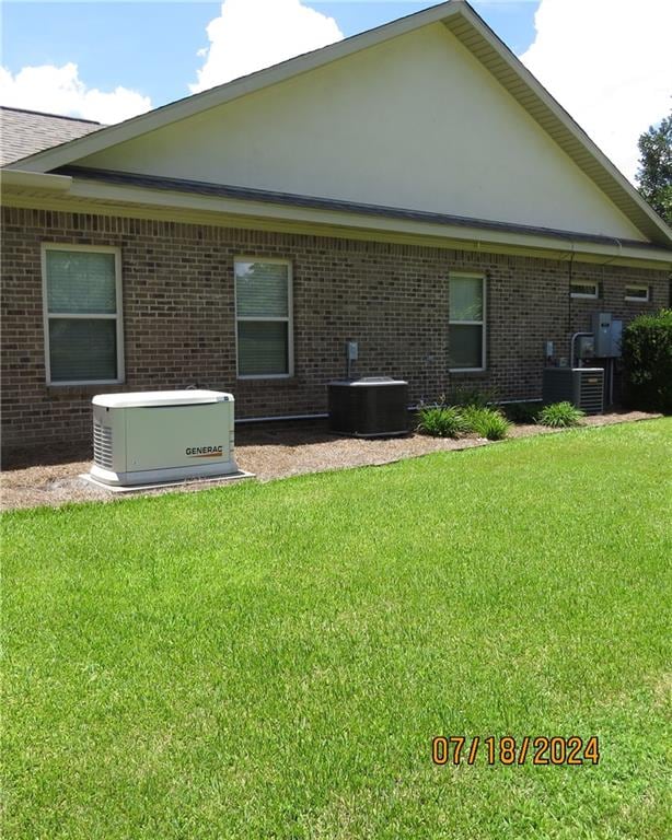 rear view of house with a lawn and central AC unit