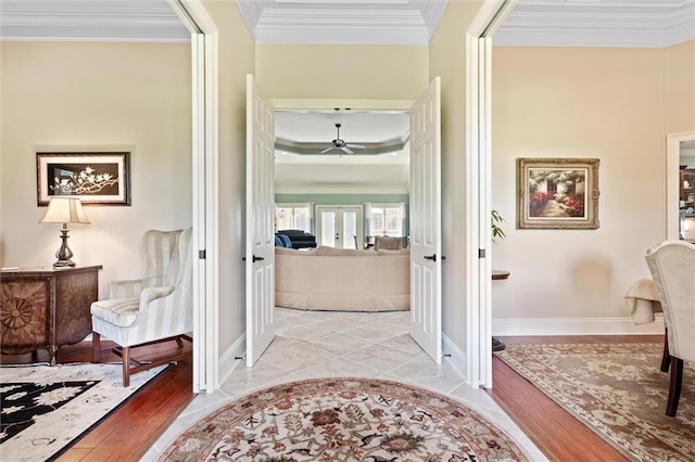 hallway featuring french doors, baseboards, crown molding, and light wood finished floors