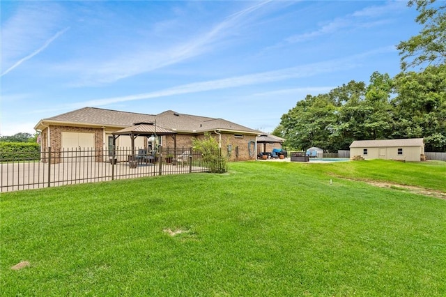 view of yard featuring a patio, fence, a gazebo, concrete driveway, and a garage