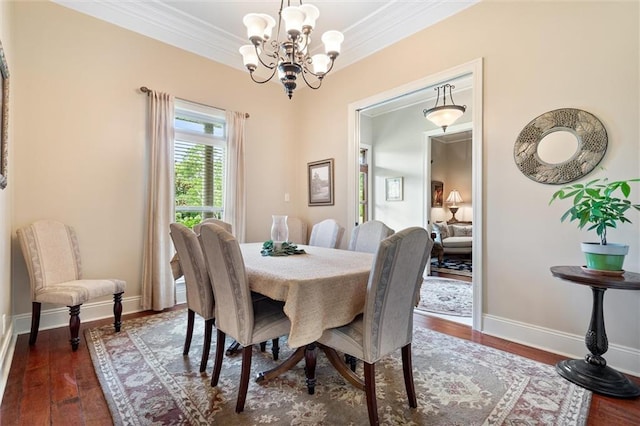 dining space featuring dark wood-type flooring, ornamental molding, baseboards, and a chandelier