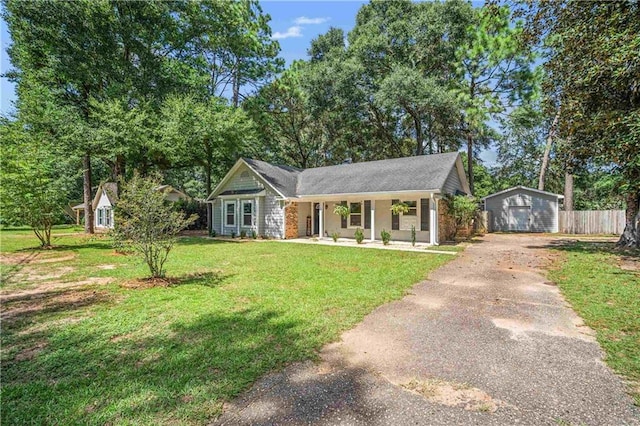 view of front facade with a front yard, a garage, and an outbuilding