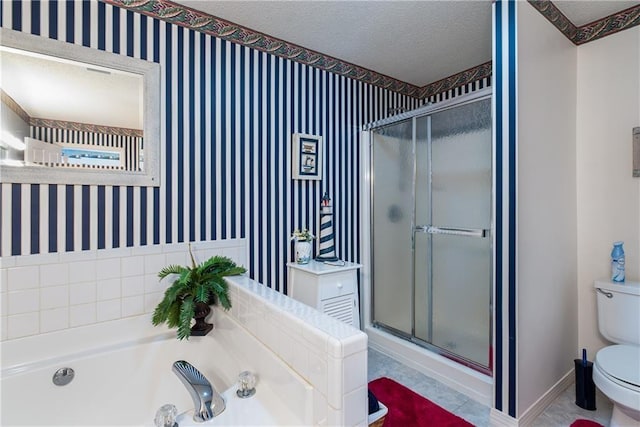 bathroom with a textured ceiling, tile floors, toilet, and separate shower and tub