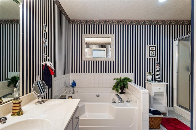 bathroom with vanity, separate shower and tub, and a textured ceiling