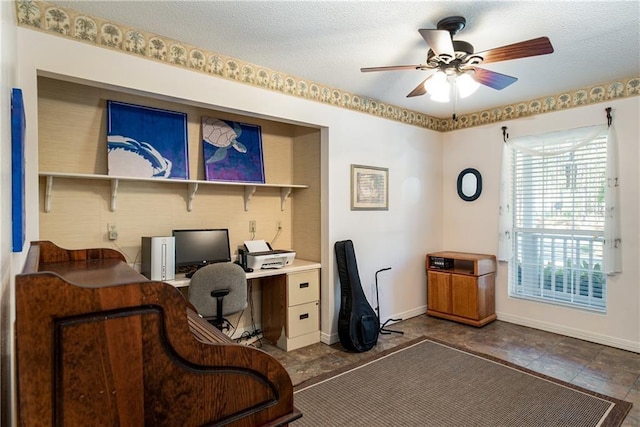 office area with dark tile floors, ceiling fan, and a textured ceiling