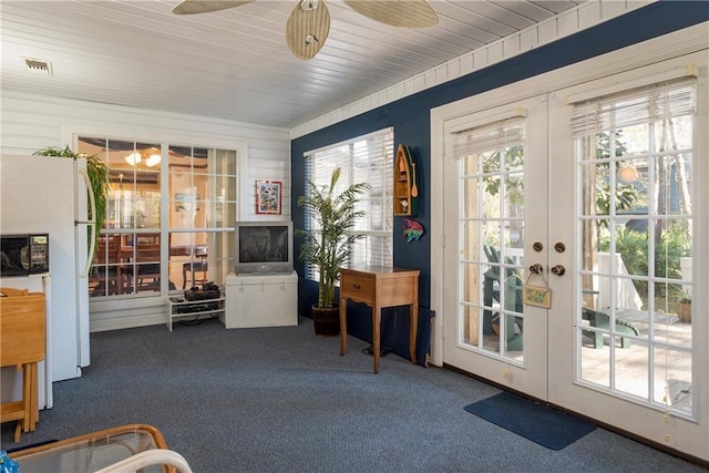 doorway featuring dark carpet, ceiling fan, and french doors