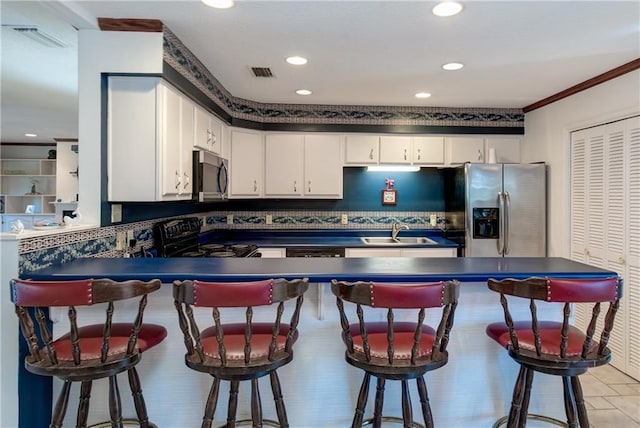 kitchen with stainless steel appliances, white cabinets, a kitchen breakfast bar, sink, and light tile floors