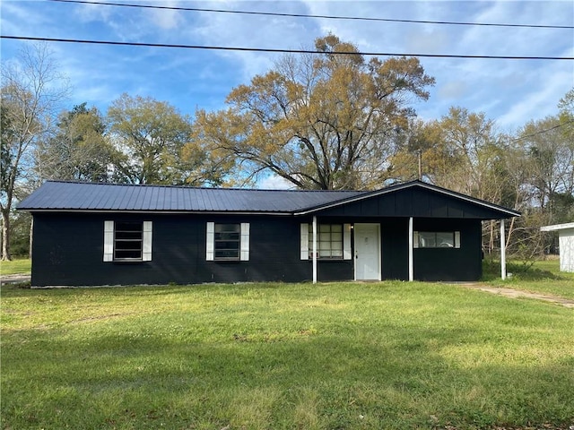 ranch-style home with a front yard and metal roof