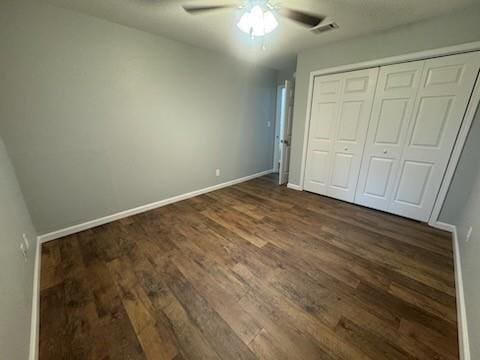 unfurnished bedroom featuring ceiling fan, dark hardwood / wood-style floors, and a closet