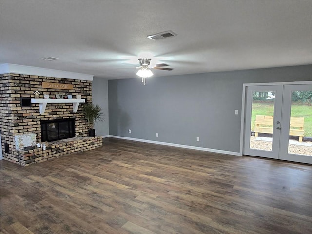 unfurnished living room featuring ceiling fan, french doors, dark hardwood / wood-style floors, and a brick fireplace