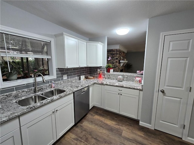 kitchen featuring light stone countertops, dark hardwood / wood-style flooring, sink, dishwasher, and white cabinetry