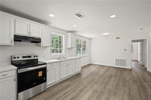 912 David Langan Dr W, Mobile, AL 36608 - kitchen with stainless steel electric range oven, under cabinet range hood, white cabinetry, light wood-style floors, and light countertops