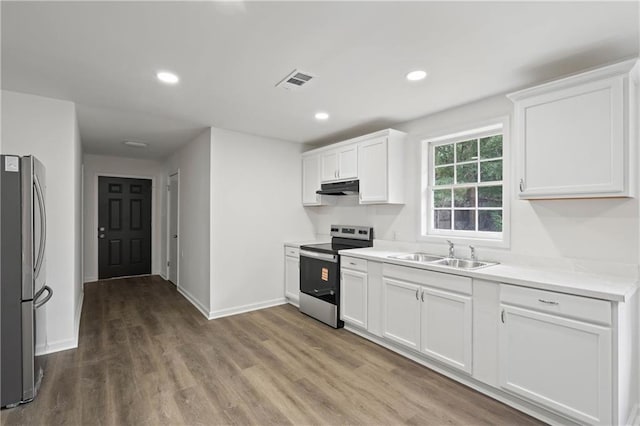 912 David Langan Dr W, Mobile, AL 36608 - kitchen with stainless steel appliances, wood finished floors, under cabinet range hood, light countertops, and white cabinets