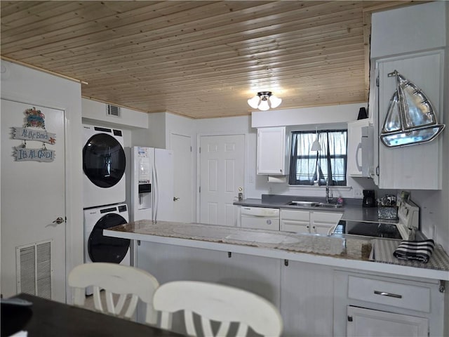 kitchen with white cabinets, wooden ceiling, white appliances, kitchen peninsula, and stacked washer / drying machine