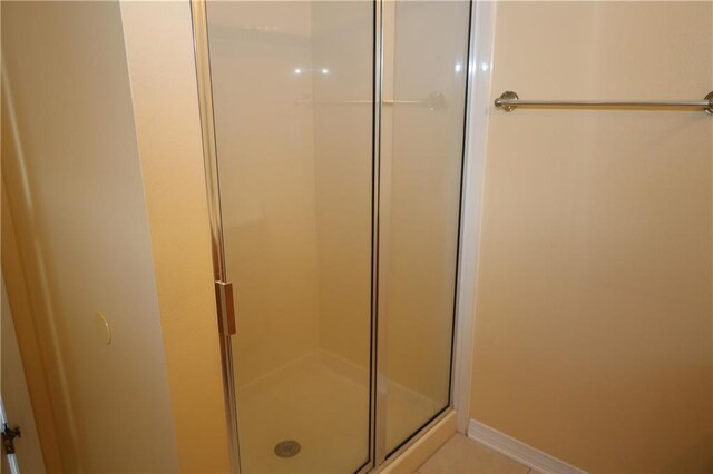 bathroom with a stall shower and baseboards