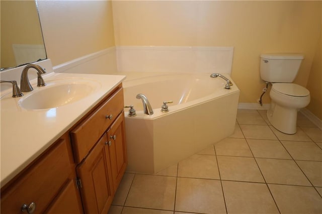 bathroom with baseboards, toilet, a bath, tile patterned floors, and vanity