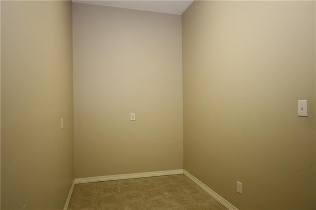 empty room featuring light floors and baseboards