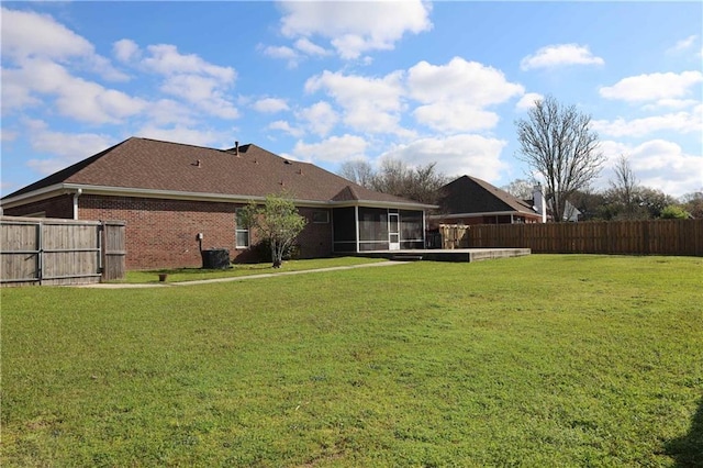 view of yard featuring central AC, a fenced backyard, and a sunroom