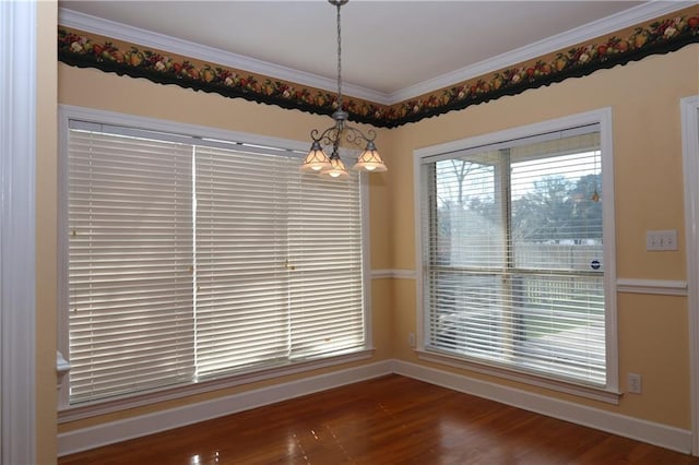 unfurnished dining area with wood finished floors, baseboards, and ornamental molding