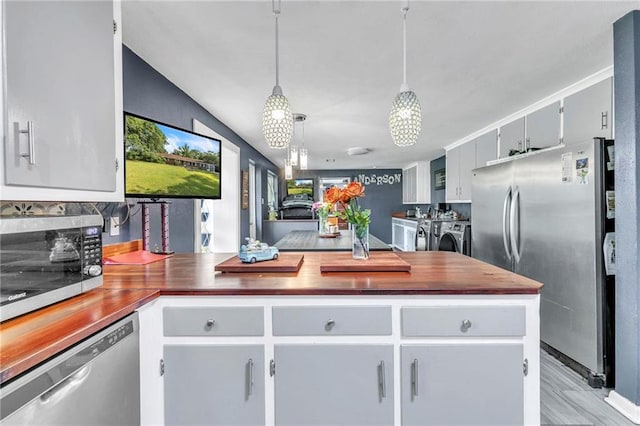 18127 County Road 10th Rd, Foley, AL 36535 - kitchen featuring pendant lighting, a peninsula, light wood-type flooring, independent washer and dryer, and stainless steel appliances