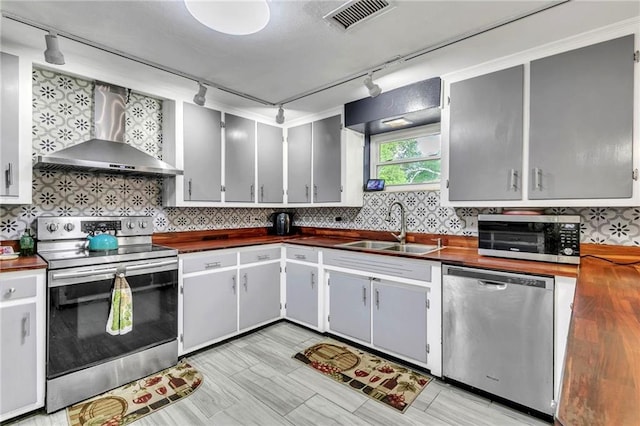18127 County Road 10th Rd, Foley, AL 36535 - kitchen with wall chimney range hood, rail lighting, appliances with stainless steel finishes, and a sink