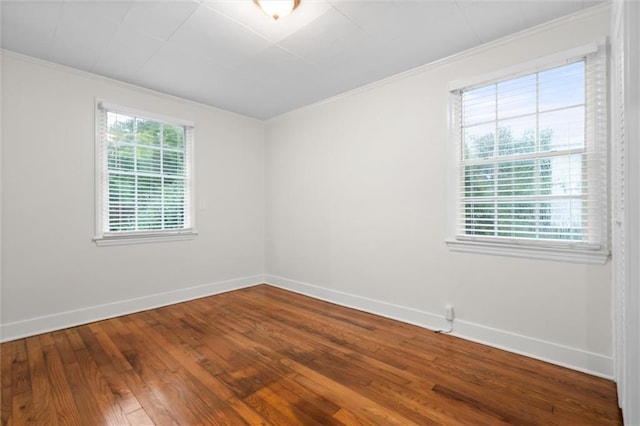 unfurnished room featuring hardwood / wood-style floors and crown molding