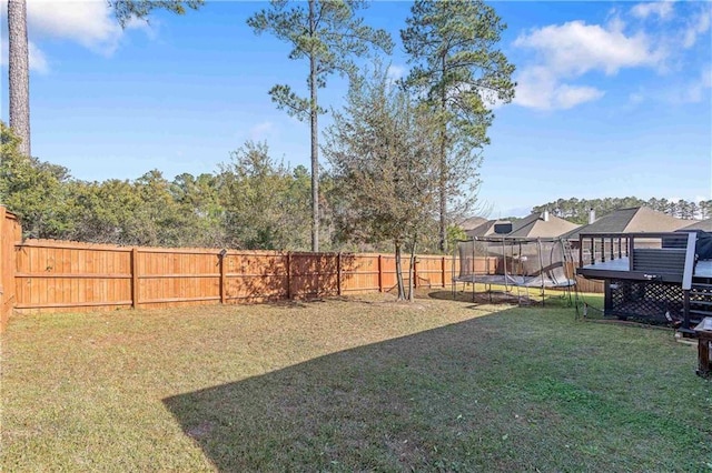 view of yard featuring a deck and a trampoline