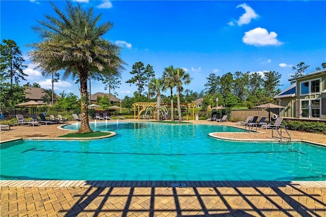 view of swimming pool with pool water feature and a patio