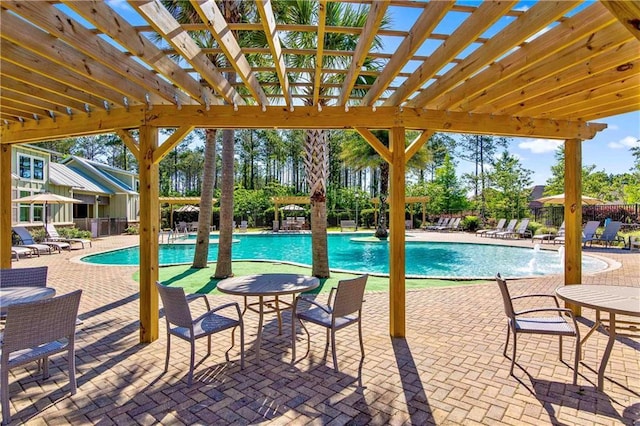 view of swimming pool with pool water feature, a patio, and a pergola